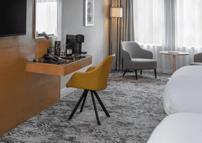 Interior of hotel rooms at Chesford Grange Hotel, featuring comfortable desk chairs, chaise longues, and tub chairs for a stylish, fresh look for this countryside retreat.
